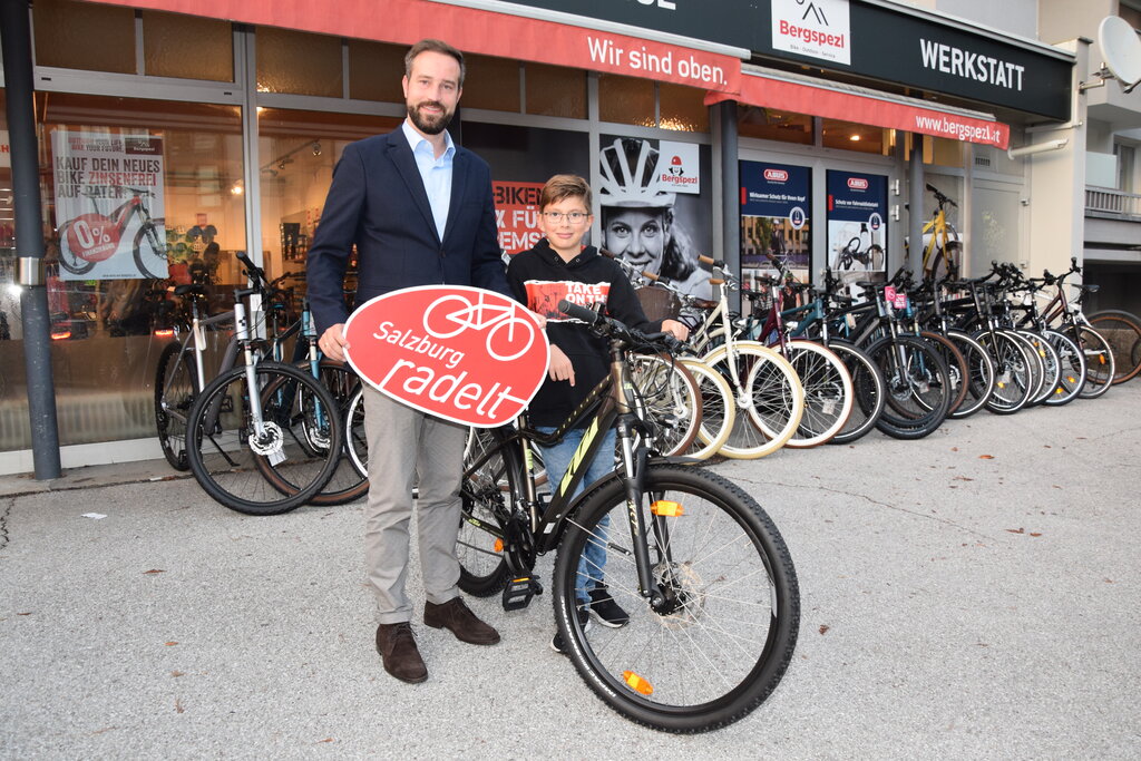 Preisverleihung Salzburg radelt 2022 Übergabe der Fahrräder an die Gewinner der Verlosung von Salzburg radelt 2022 mit LR Stefan Schnöll am 19.10.2022 bei Preis-Sponsor Bergspezl in der Stadt Salzburg. im Bild: LR Stefan Schnöll mit Sebastian Kendler